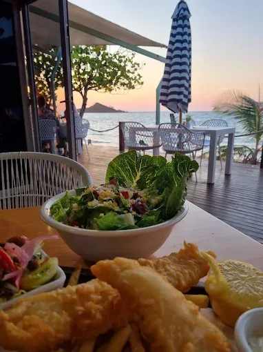 Fish and chips, salad, and a beachside restaurant at sunset — The Beach Bar and Restaurant at Montes in Cape Gloucester, QLD