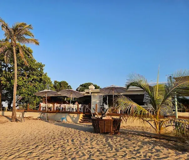 Beachside restaurant with tables under umbrellasy — The Beach Bar and Restaurant at Montes in Cape Gloucester, QLD