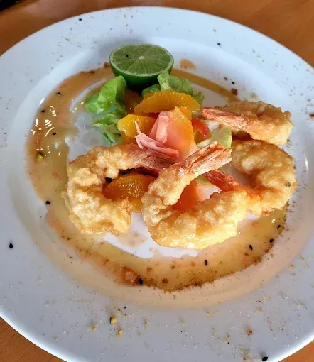 Tempura shrimp on a plate with sauce, fruit, and lime — The Beach Bar and Restaurant at Montes in Cape Gloucester, QLD