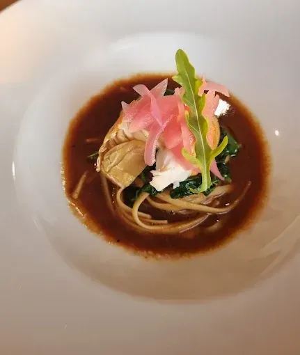 Pasta with dark sauce, topped with pickled onions and greens — The Beach Bar and Restaurant at Montes in Cape Gloucester, QLD