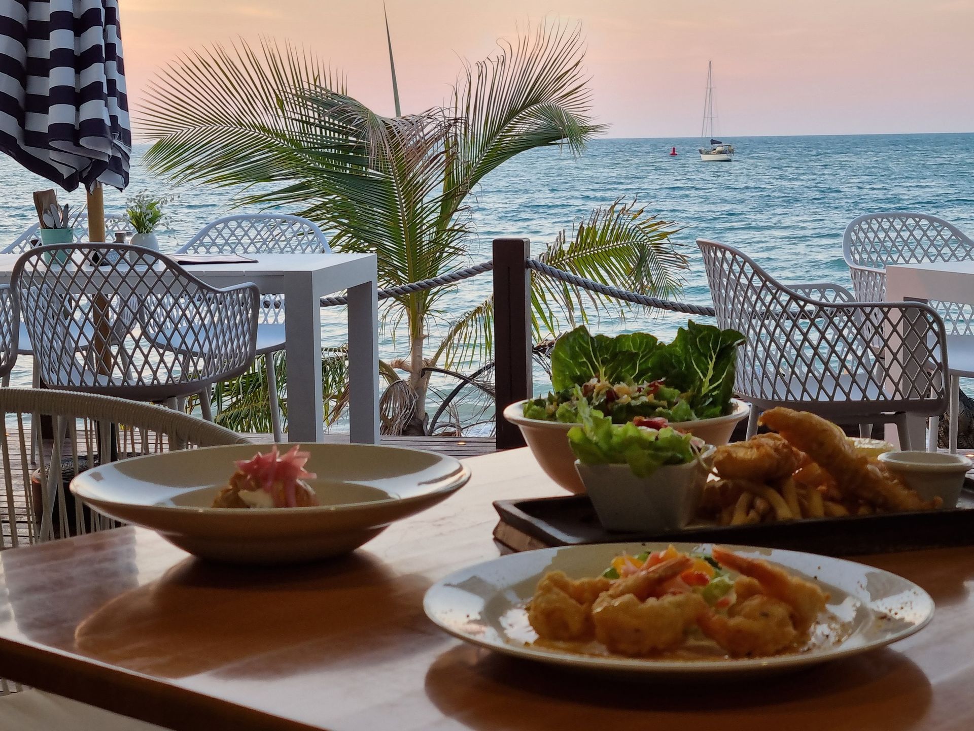 Couple Dining at an Oceanfront Restaurant — The Beach Bar and Restaurant at Montes in Cape Gloucester, QLD