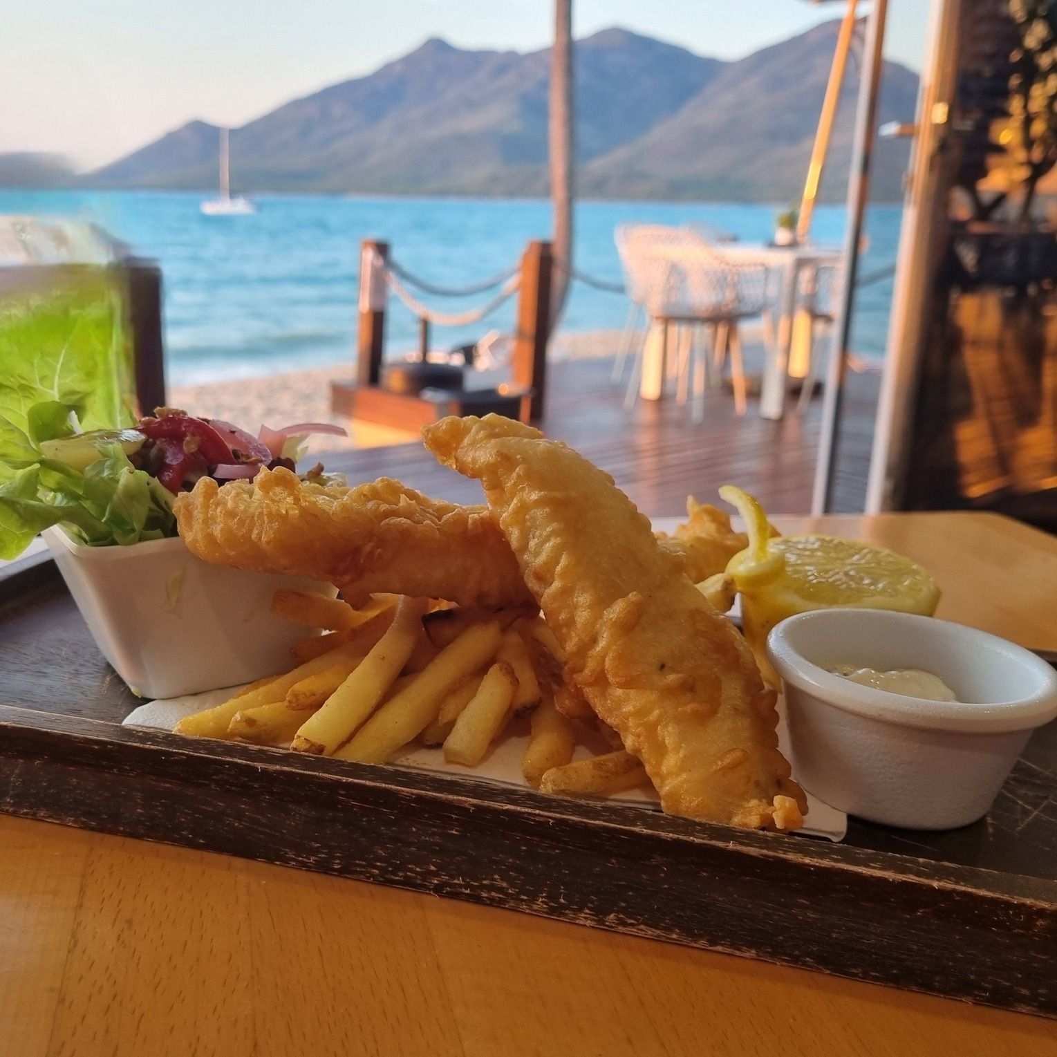 Fish and chips with salad and sauce, served outdoors — The Beach Bar and Restaurant at Montes in Cape Gloucester, QLD