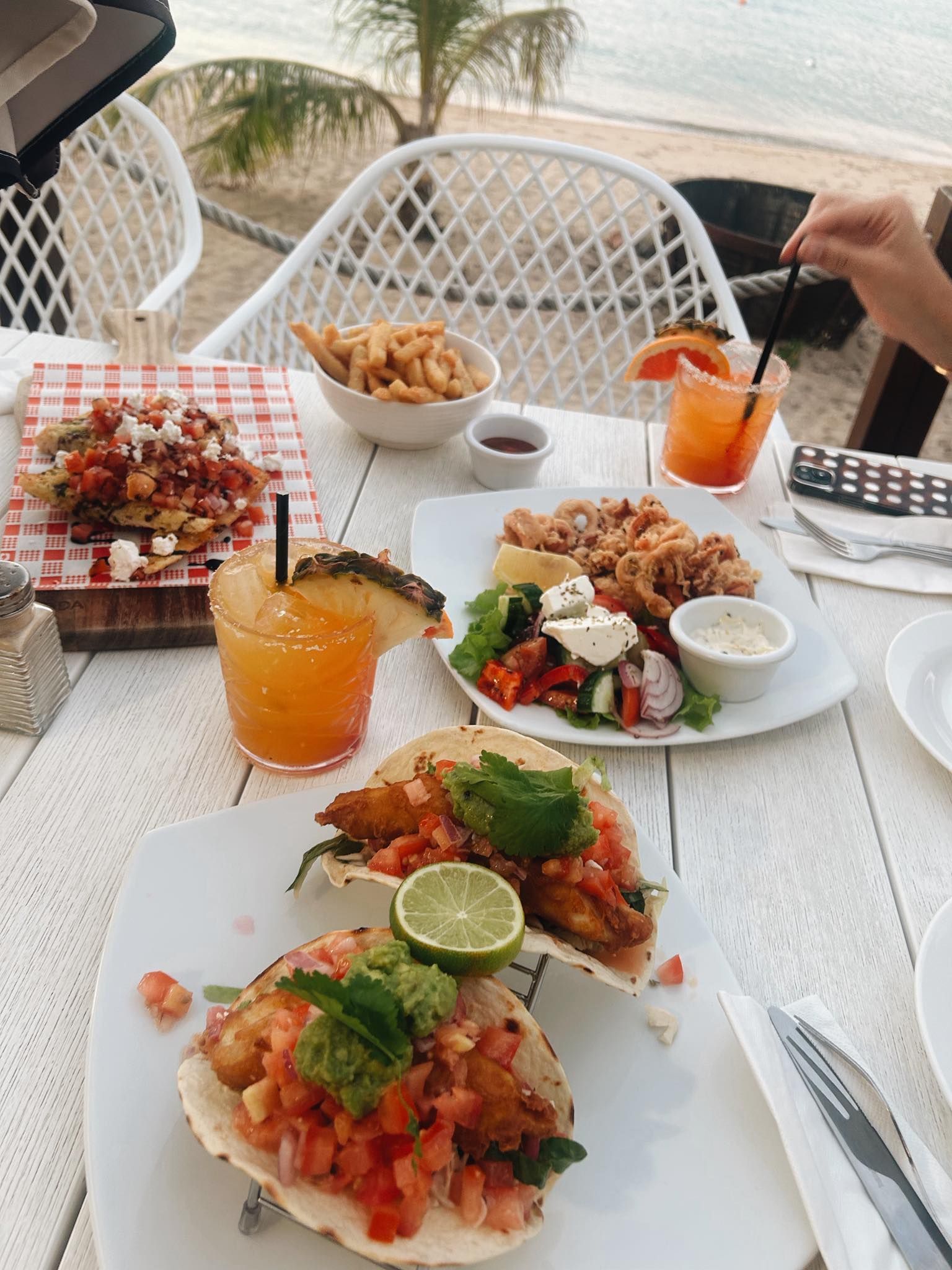 Beachside table with seafood, drinks, and cocktails — The Beach Bar and Restaurant at Montes in Cape Gloucester, QLD