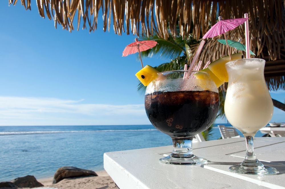 Two Tropical Cocktails With Umbrellas on a White Table — The Beach Bar and Restaurant at Montes in Cape Gloucester, QLD