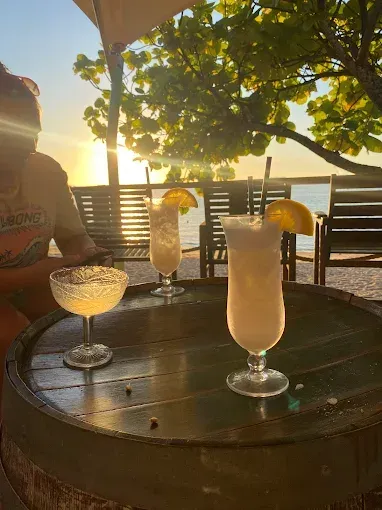 Cocktails on a table at sunset — The Beach Bar and Restaurant at Montes in Cape Gloucester, QLD