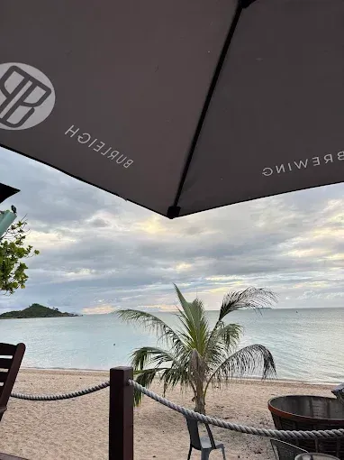 Beachside view under a umbrella — The Beach Bar and Restaurant at Montes in Cape Gloucester, QLD