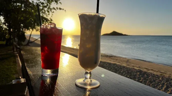 Two cocktails on a wooden ledge at sunset — The Beach Bar and Restaurant at Montes in Cape Gloucester, QLD