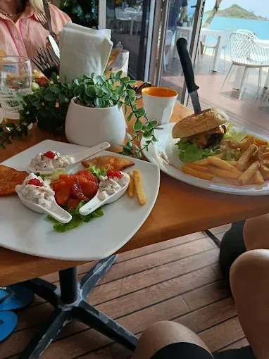 A burger with fries and appetizers in an outdoor setting — The Beach Bar and Restaurant at Montes in Cape Gloucester, QLD