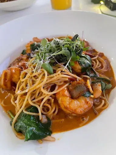 Spaghetti with shrimp in orange sauce, spinach, and sprouts — The Beach Bar and Restaurant at Montes in Cape Gloucester, QLD