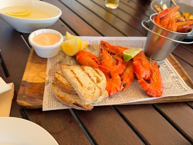 Platter with crayfish, toasted bread, lemon, and a drink — The Beach Bar and Restaurant at Montes in Cape Gloucester, QLD