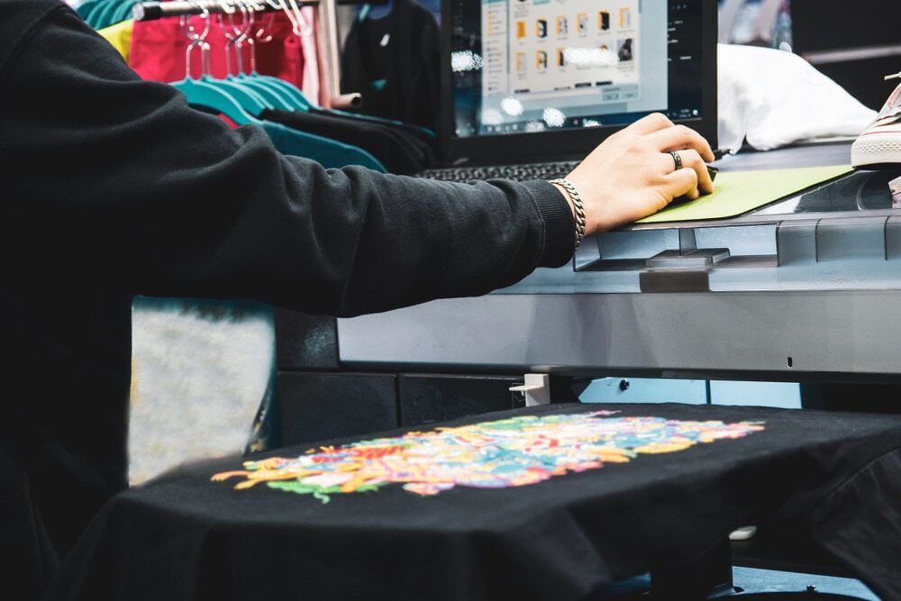 Person Using a Computer Controls a Printer for Vibrant T-shirt Designs — DXMA Designs In Campbelltown, NSW