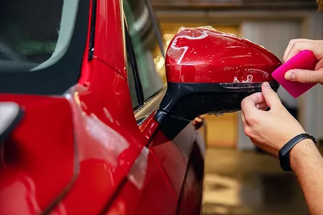 A Man Wrapping the Mirror on a Red Car — DXMA Designs In Bargo, NSW