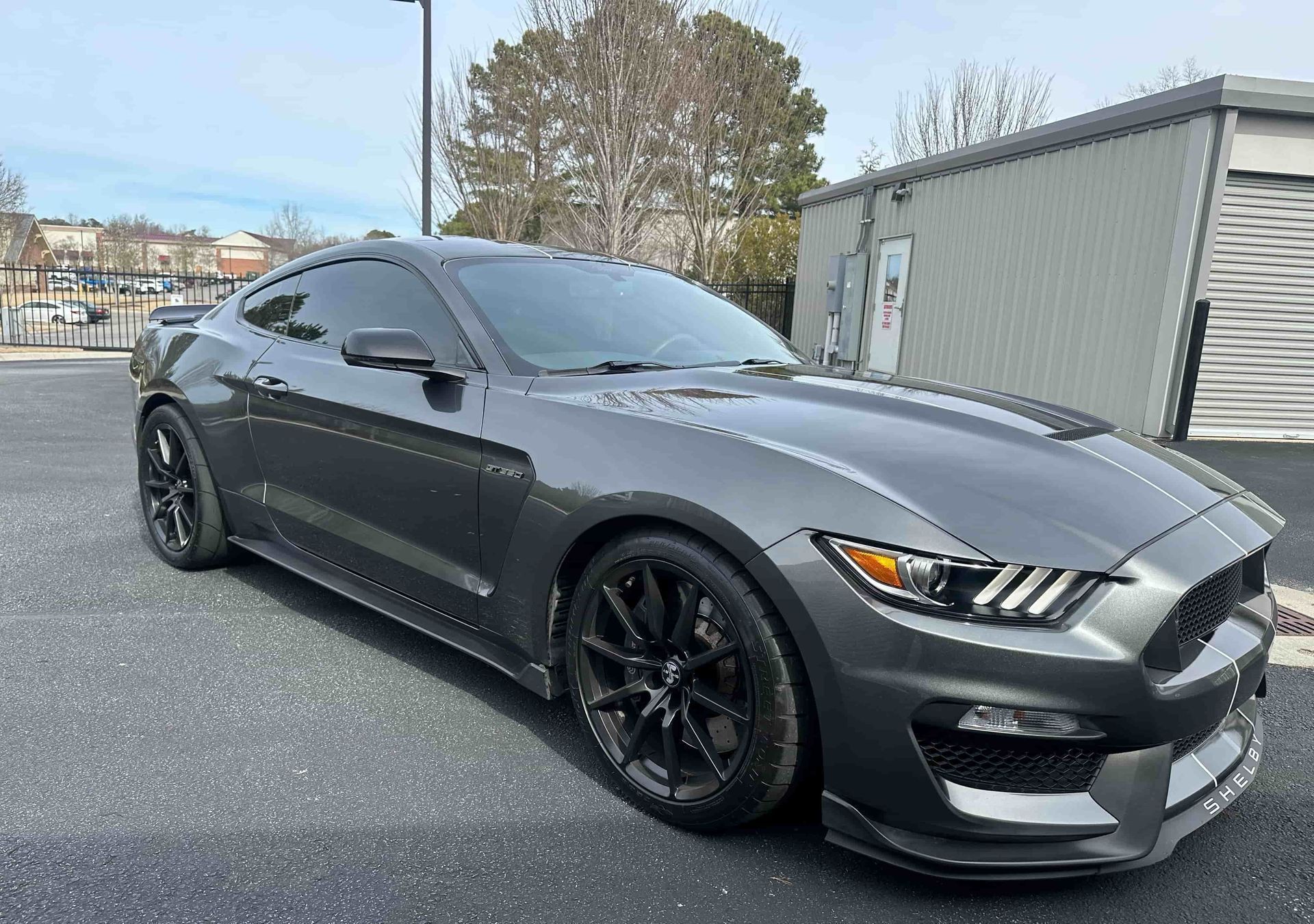 Gray Ford Mustang Shelby GT350 parked on asphalt.