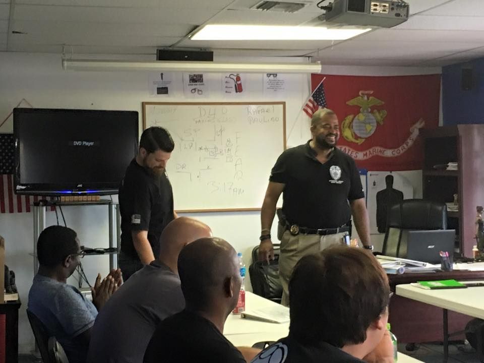 A group of men are in a room with a flag on the wall