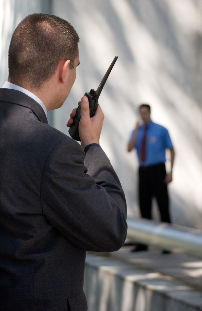 A man in a suit is talking on a walkie talkie