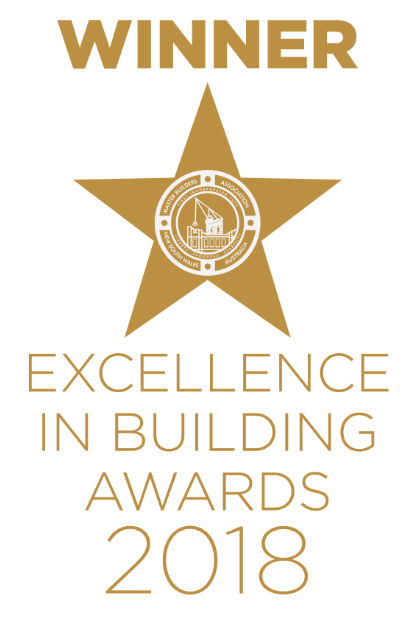Winner of the Excellence in Building Awards 2018. Gold star with logo, gold text on white background.