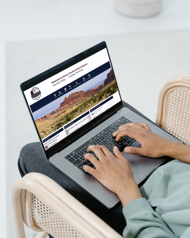 a person is typing on a laptop computer while sitting in a chair .