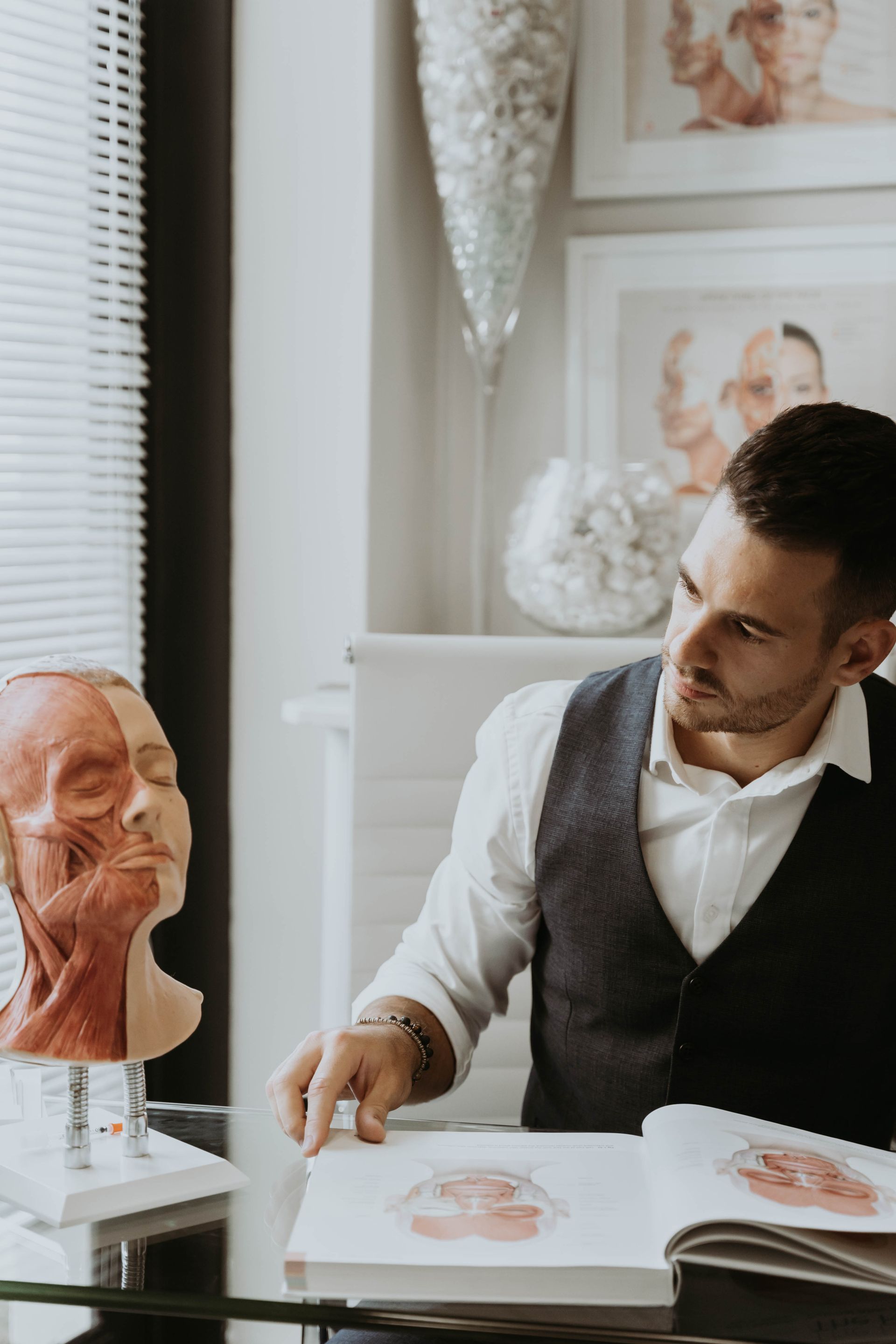 A man is sitting at a table looking at a book.