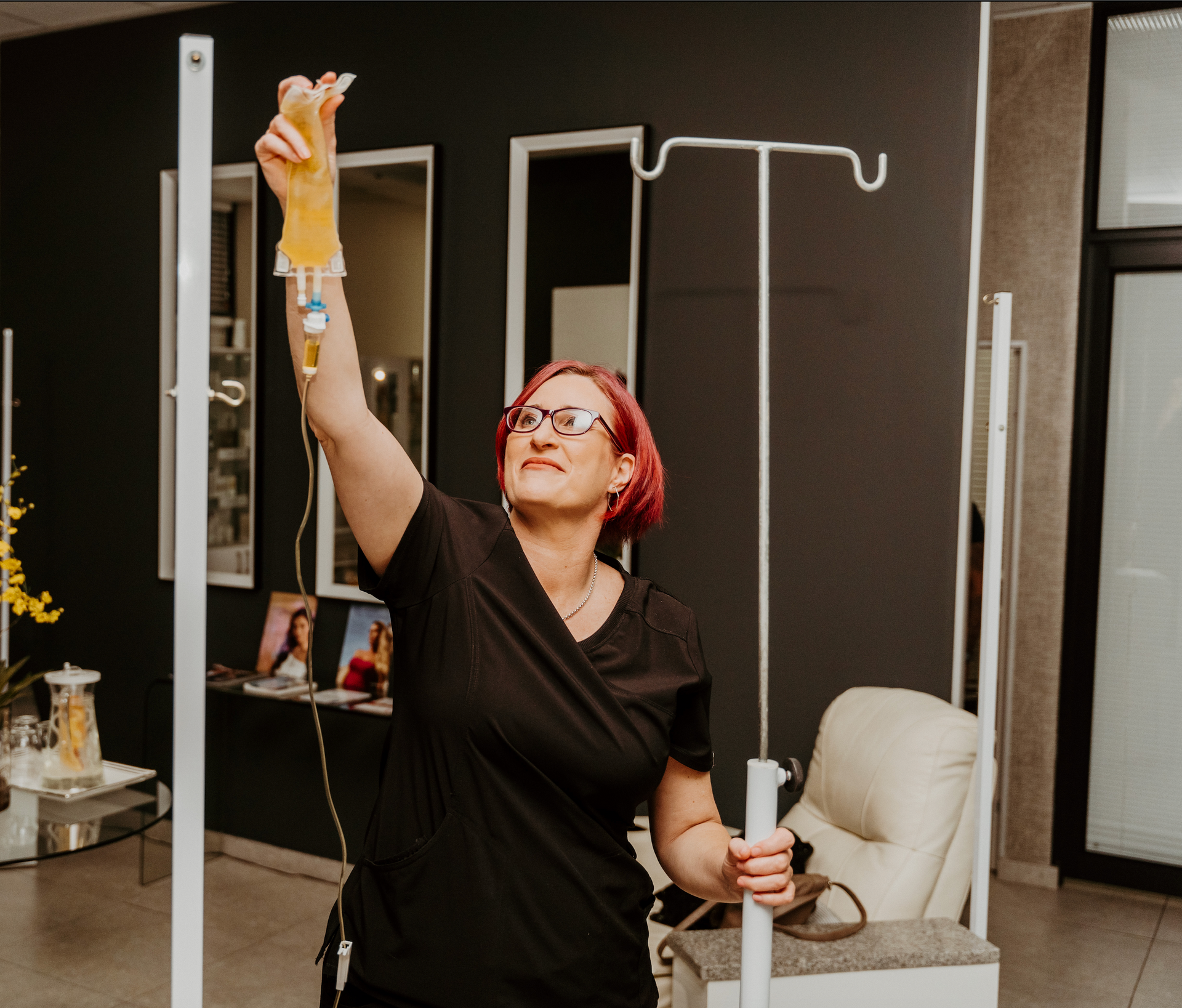 A woman in a black shirt is holding a drip in her hand.