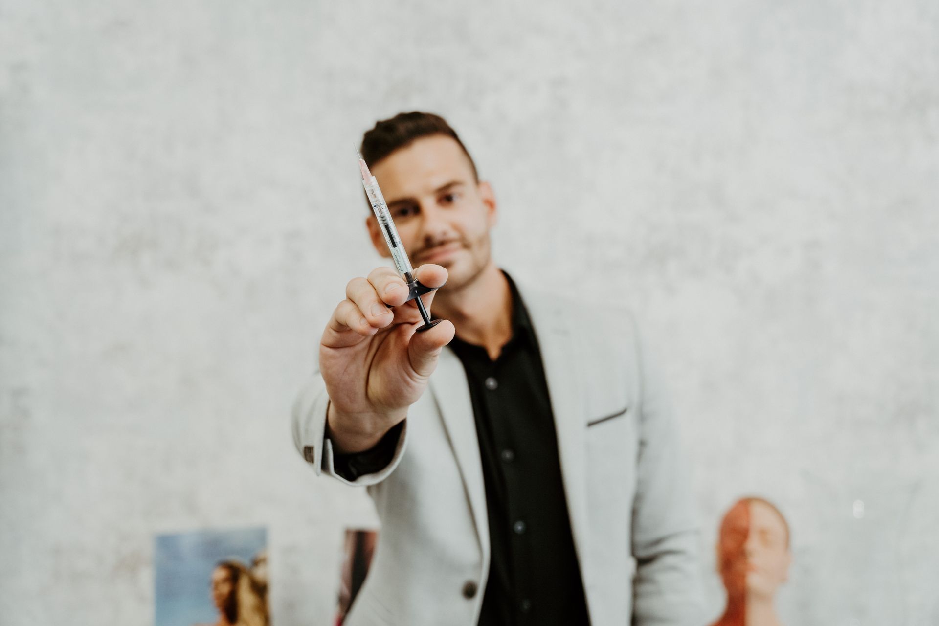 A man in a suit is holding a pair of scissors in his hand.
