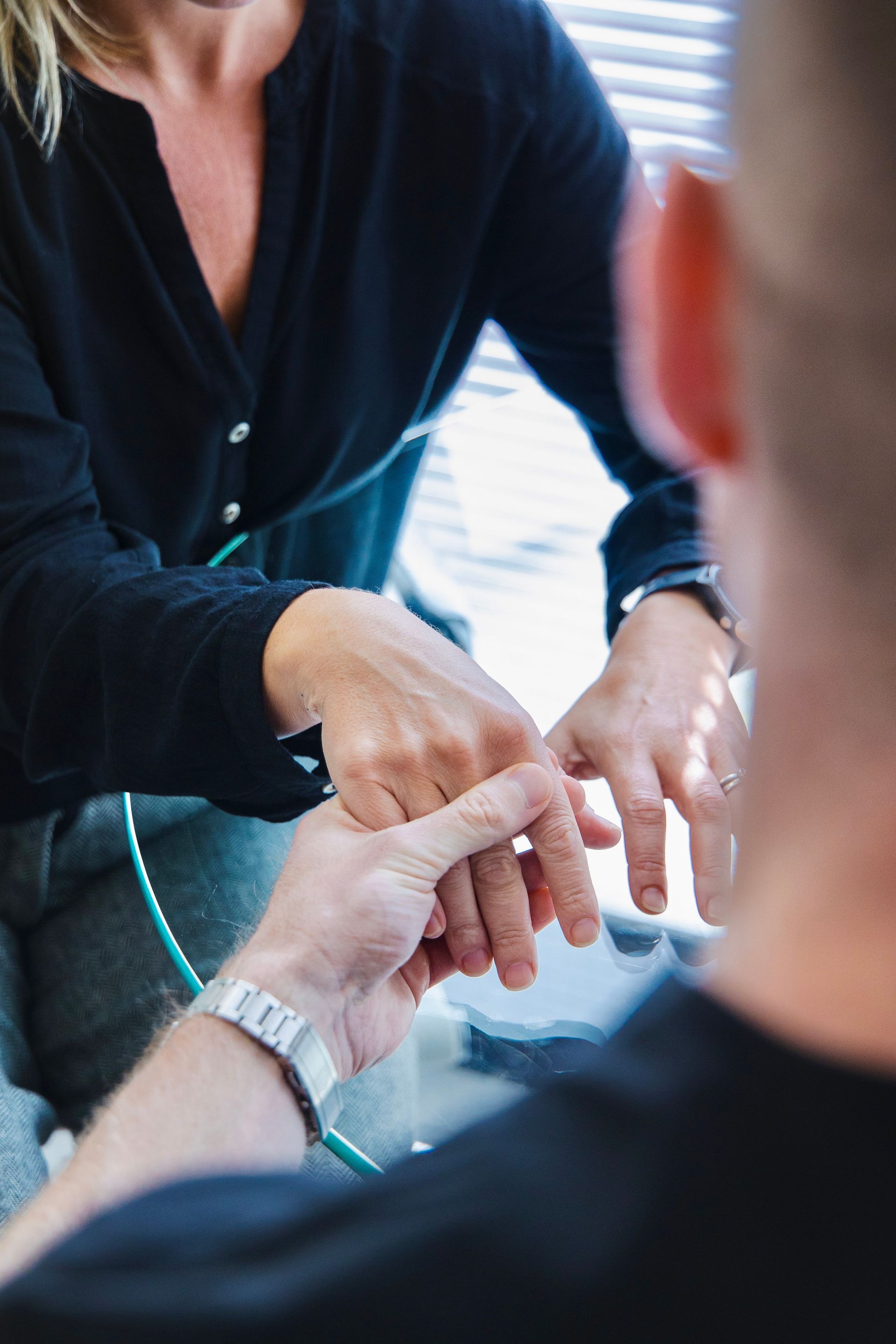 A woman is touching a man 's hand while sitting at a table.