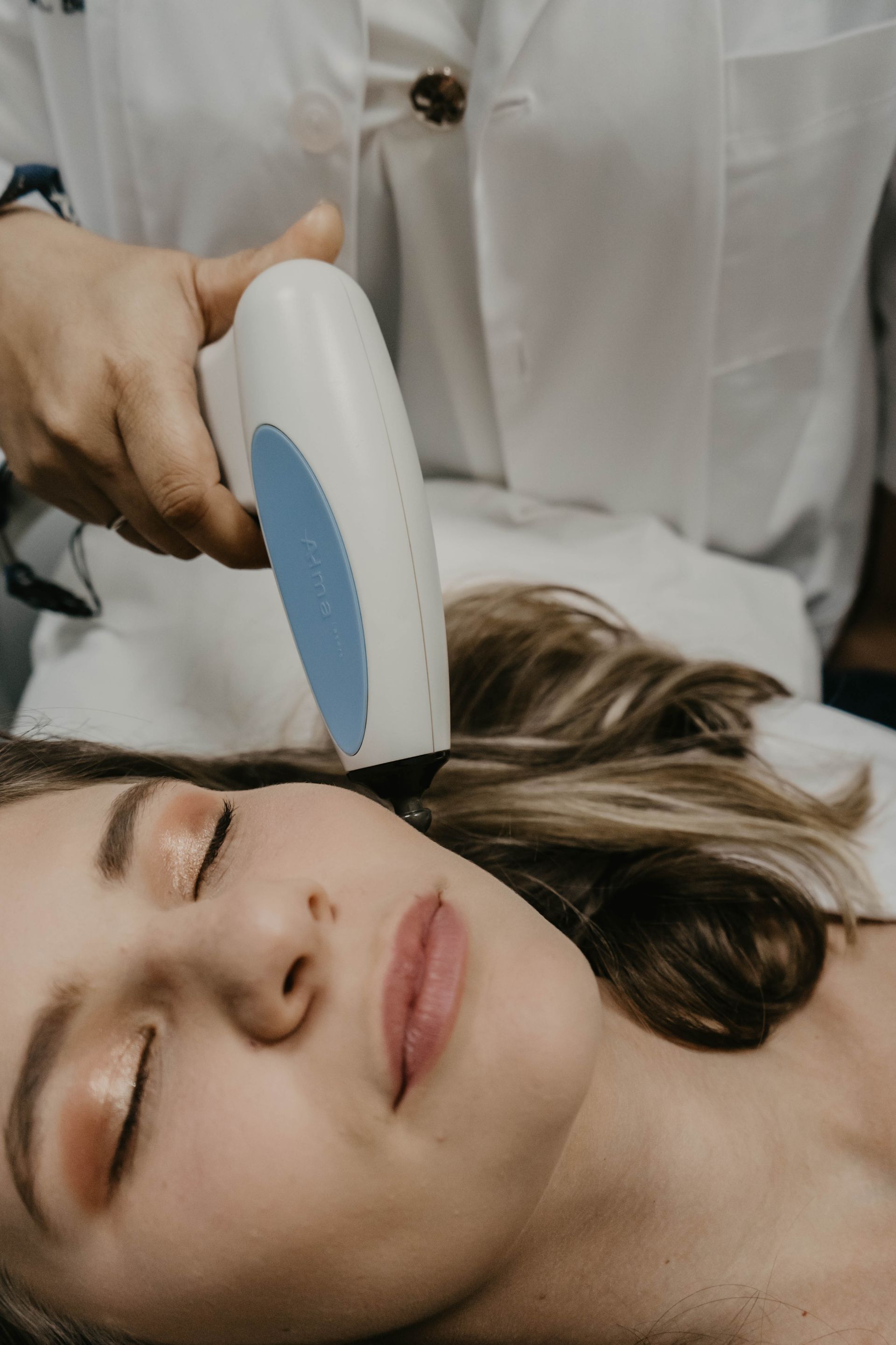 A woman is getting a laser treatment on her face.