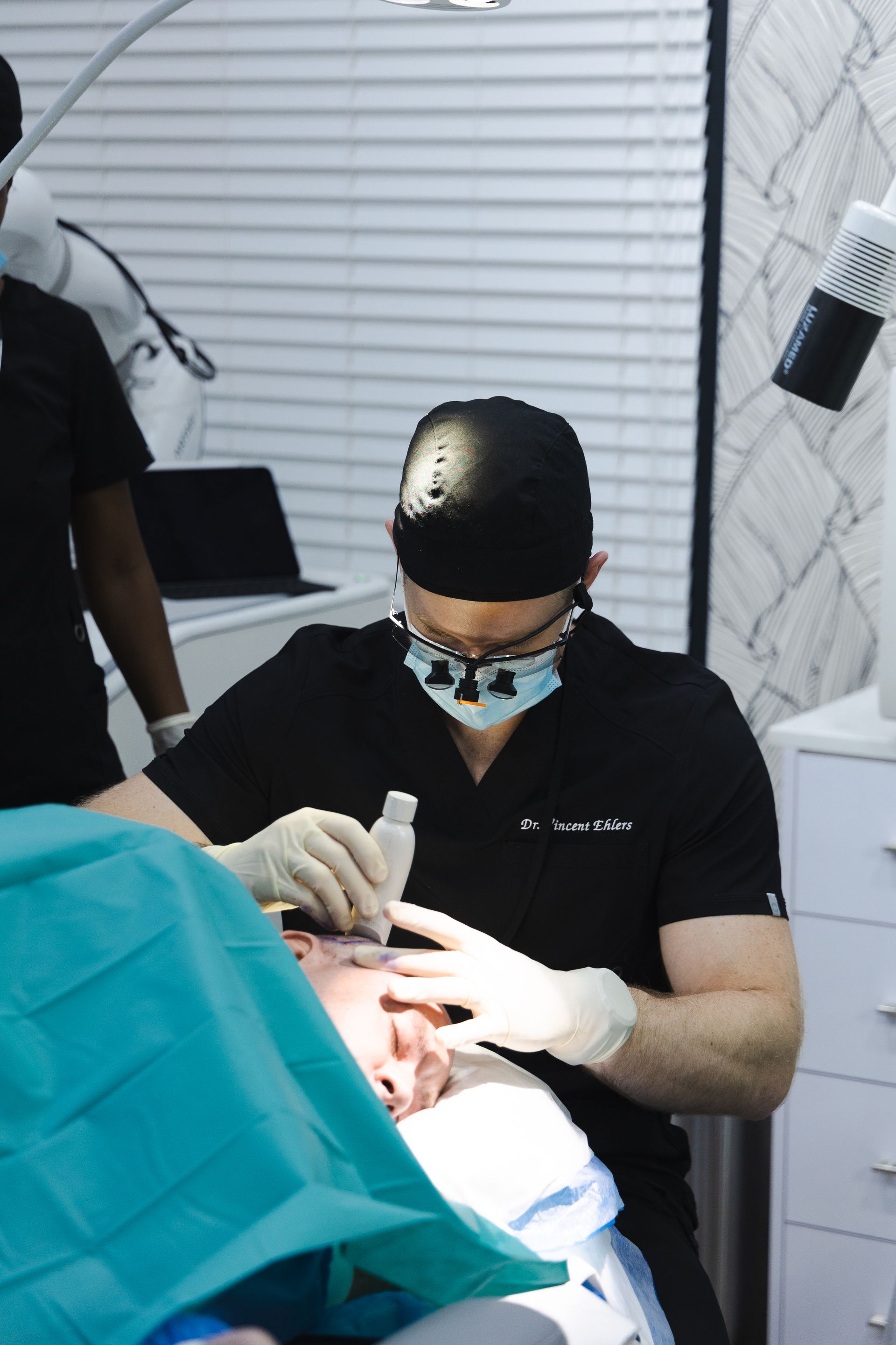 A dentist is working on a patient 's teeth in a dental office.