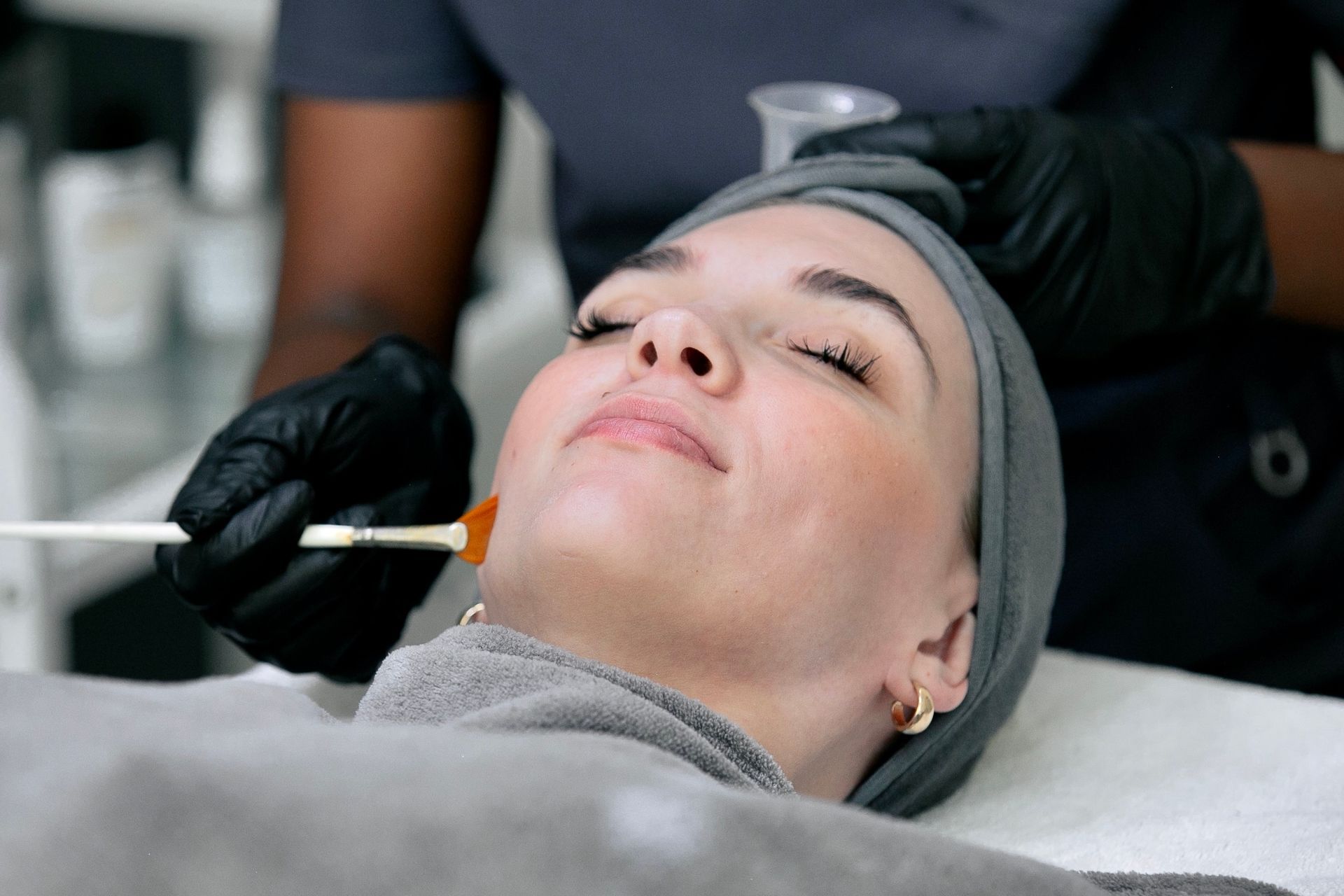 A woman is getting a facial treatment at a beauty salon.