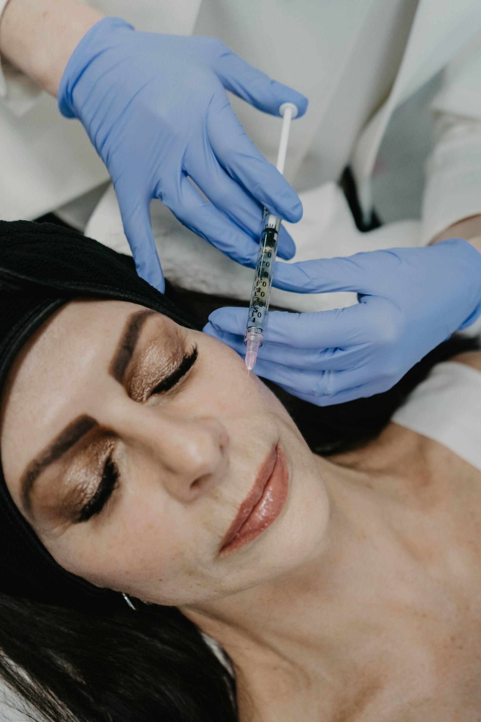 A woman is getting a botox injection in her face.