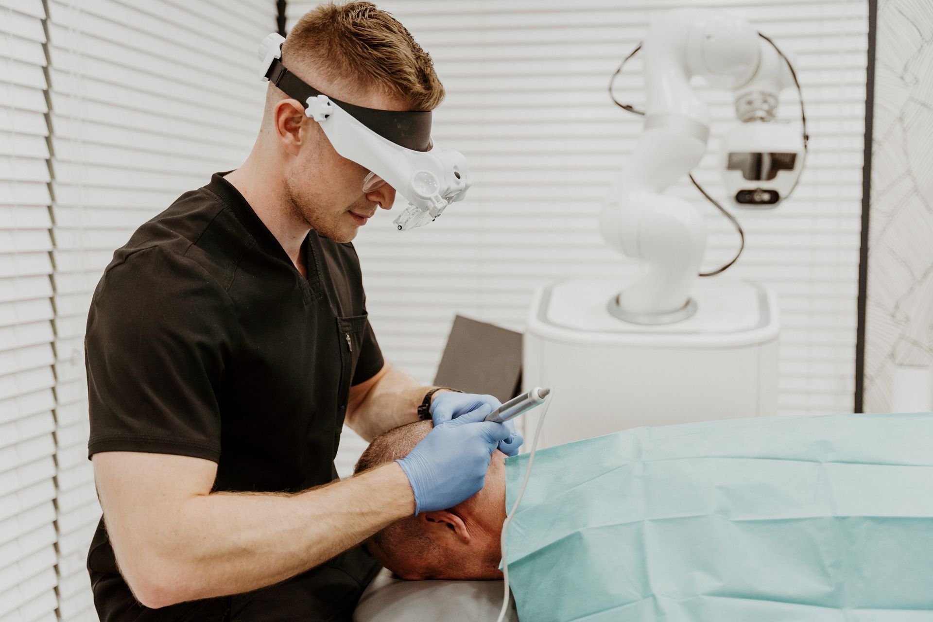 A man is using a magnifying glass to look at a patient 's face.