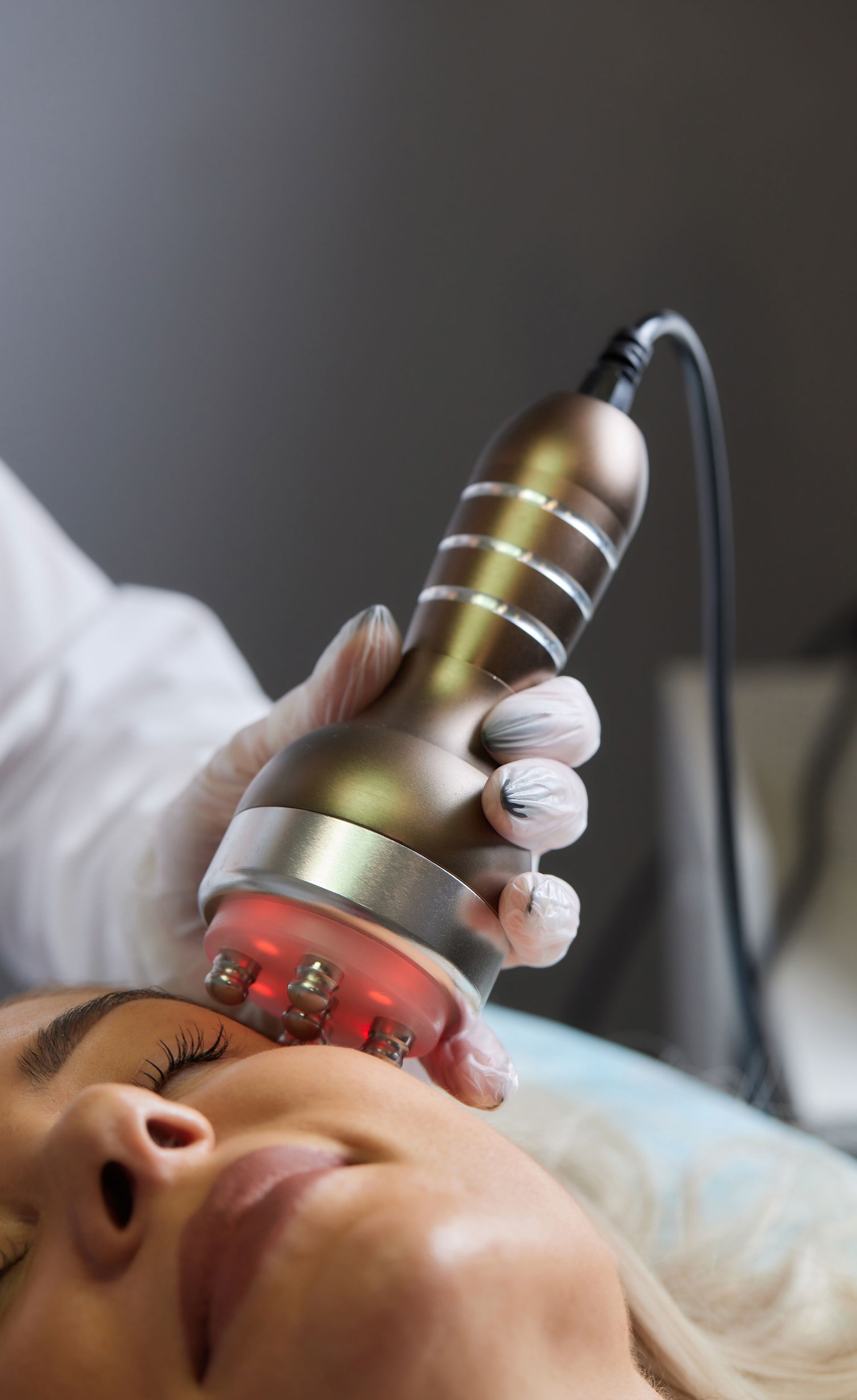 A woman is getting a cavitation treatment on her face.