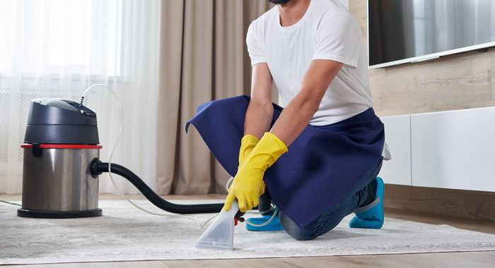 a man is cleaning the floor with a vacuum