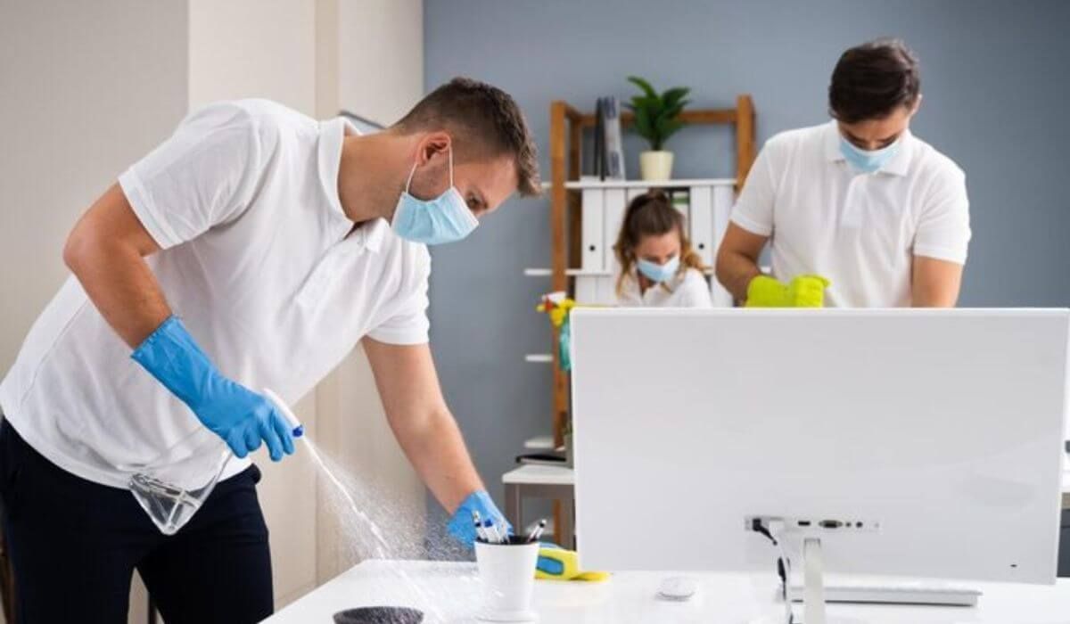employee wiping office desk
