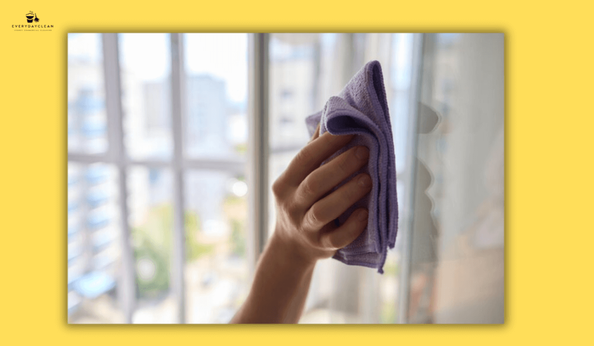 hand wiping glass with a microfiber towel