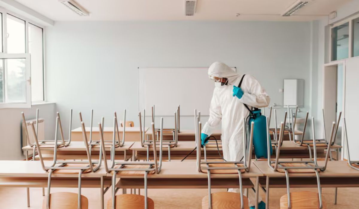 school janitor cleaning classroom desk