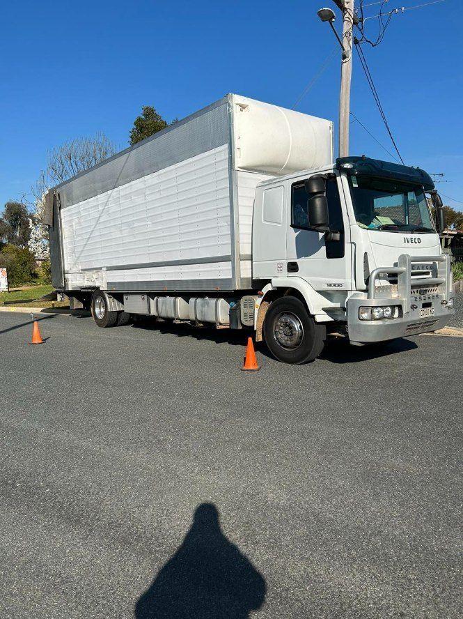 A White Truck is Parked in a Parking Lot Next to Orange Cones — Buck Removals & Storage in Dubbo, NSW