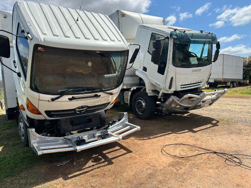 Two White Trucks Are Parked Next to Each Other in a Dirt Lot — Buck Removals & Storage in Griffith, NSW