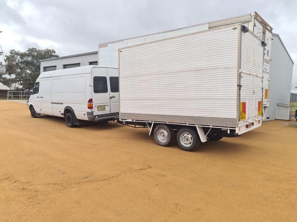 Two White Vans Are Parked Next to Each Other in a Dirt Lot — Buck Removals & Storage in Wagga Wagga, NSW