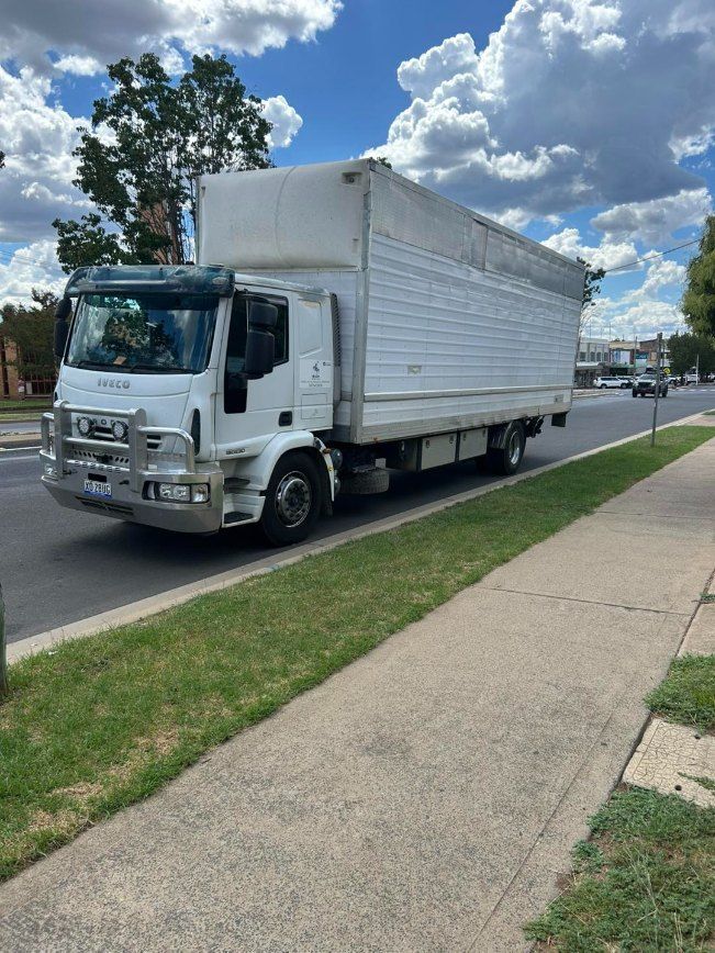 A White Truck is Parked on the Side of the Road Next to a Sidewalk — Buck Removals & Storage in Forbes, NSW