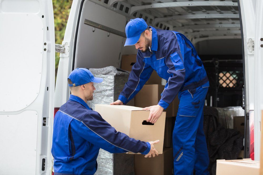 Two Delivery Men Are Loading Boxes Into a Van — Buck Removals & Storage in Cowra, NSW