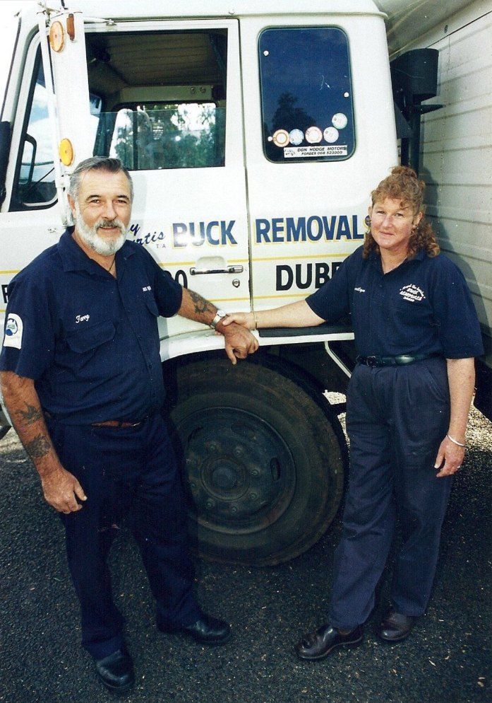 A Man and Woman Standing in Front of a Truck That Says Duck Removal — Buck Removals & Storage in Cowra, NSW
