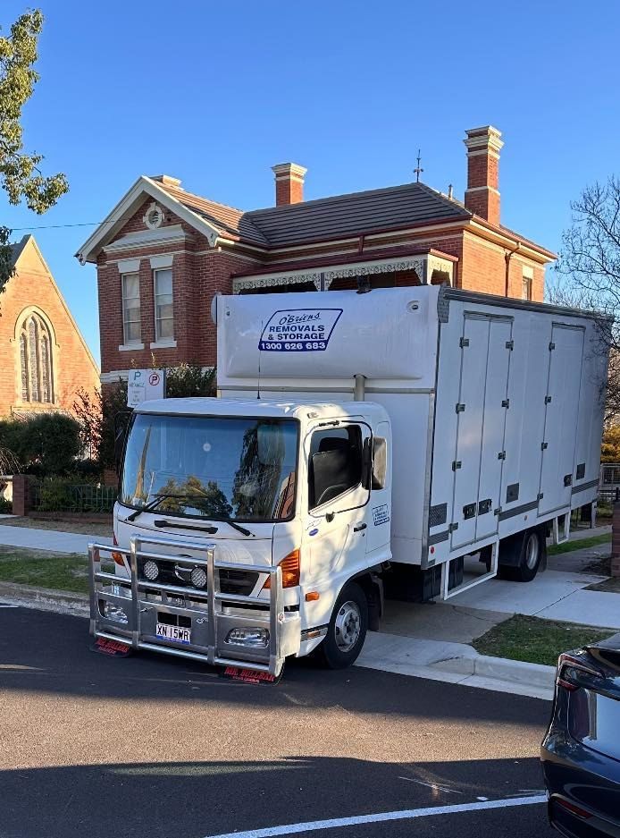 A White Moving Truck is Parked on the Side of the Road — Buck Removals & Storage in Cowra, NSW