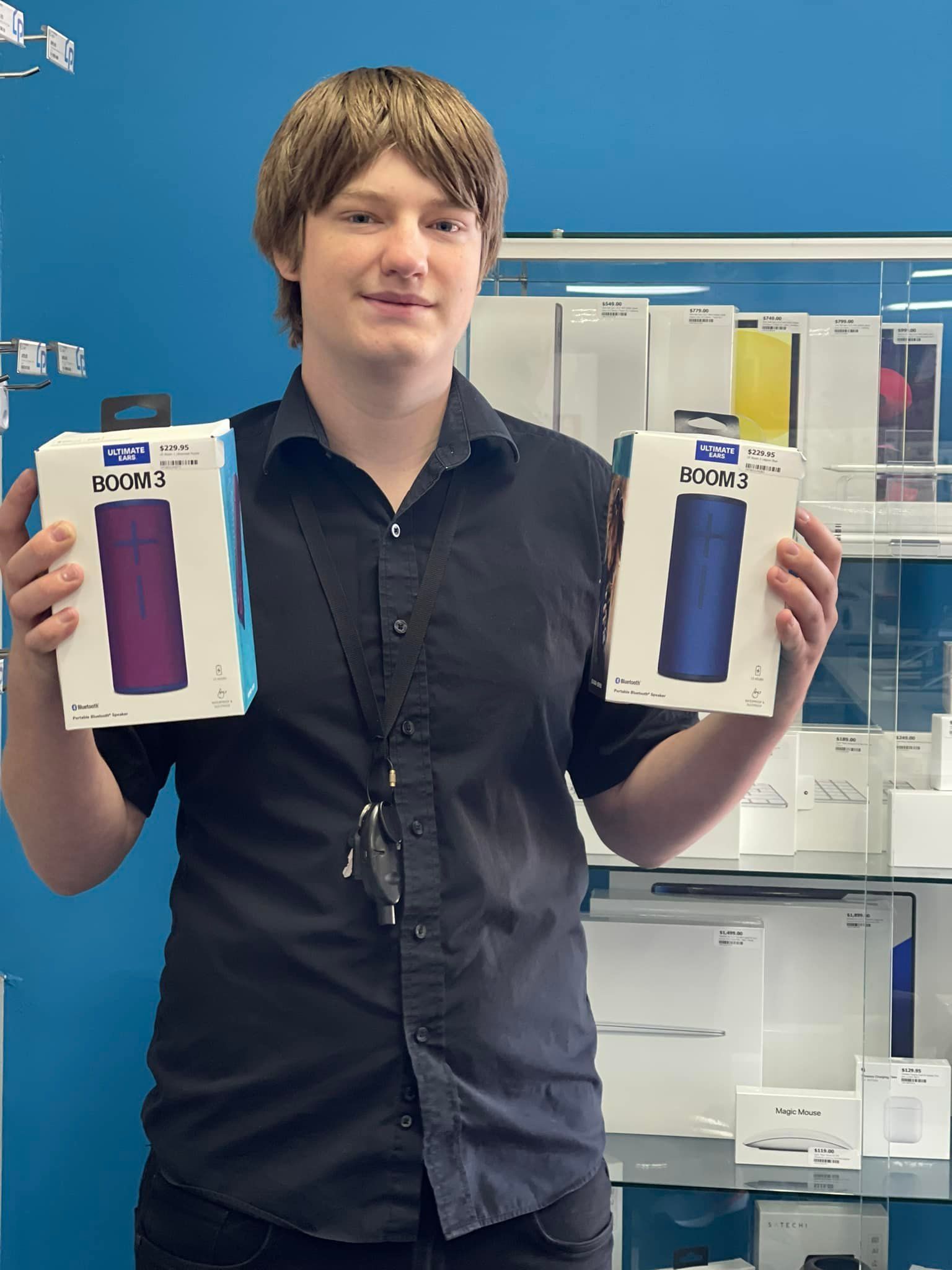 A Person Holds Two Packaged Bluetooth Speakers in a Store — Phone Hut in Alice Springs, NT