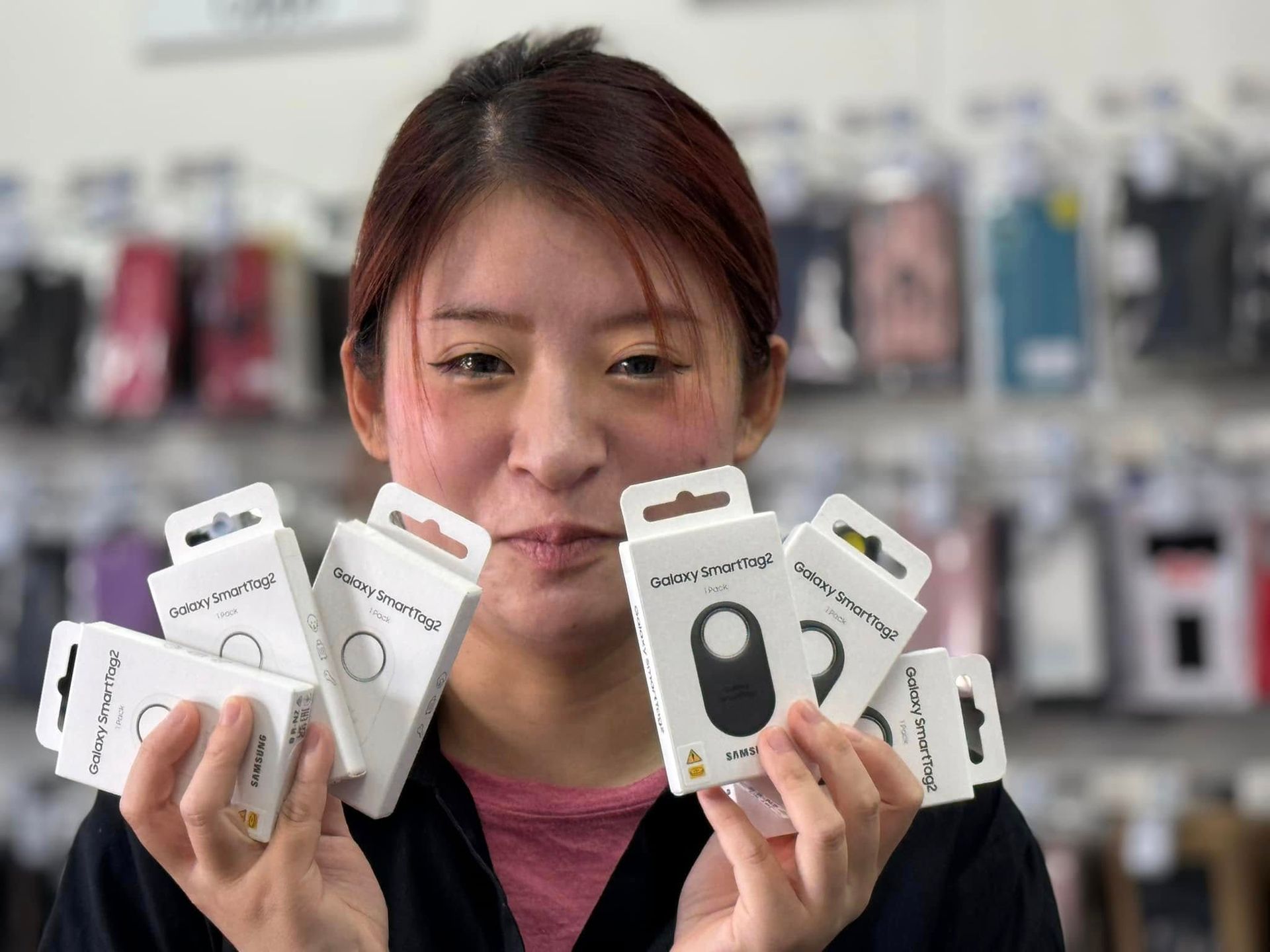 Woman Holding Multiple Phone Accessory Packages in a Store — Phone Hut in Alice Springs, NT