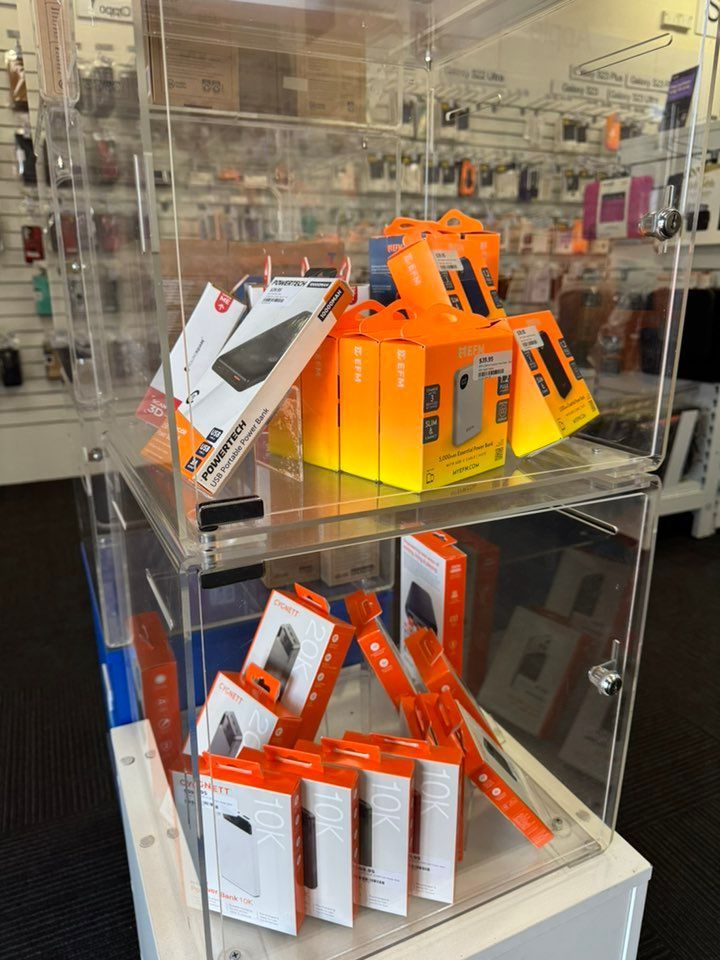 Clear Display Case With Orange and White Product Boxes Inside a Store — Phone Hut in Alice Springs, NT