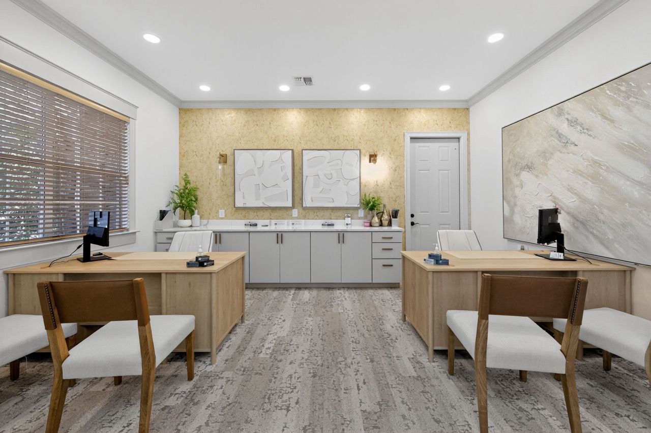 Leasing office with two desks, computers, and neutral decor in a modern common area.