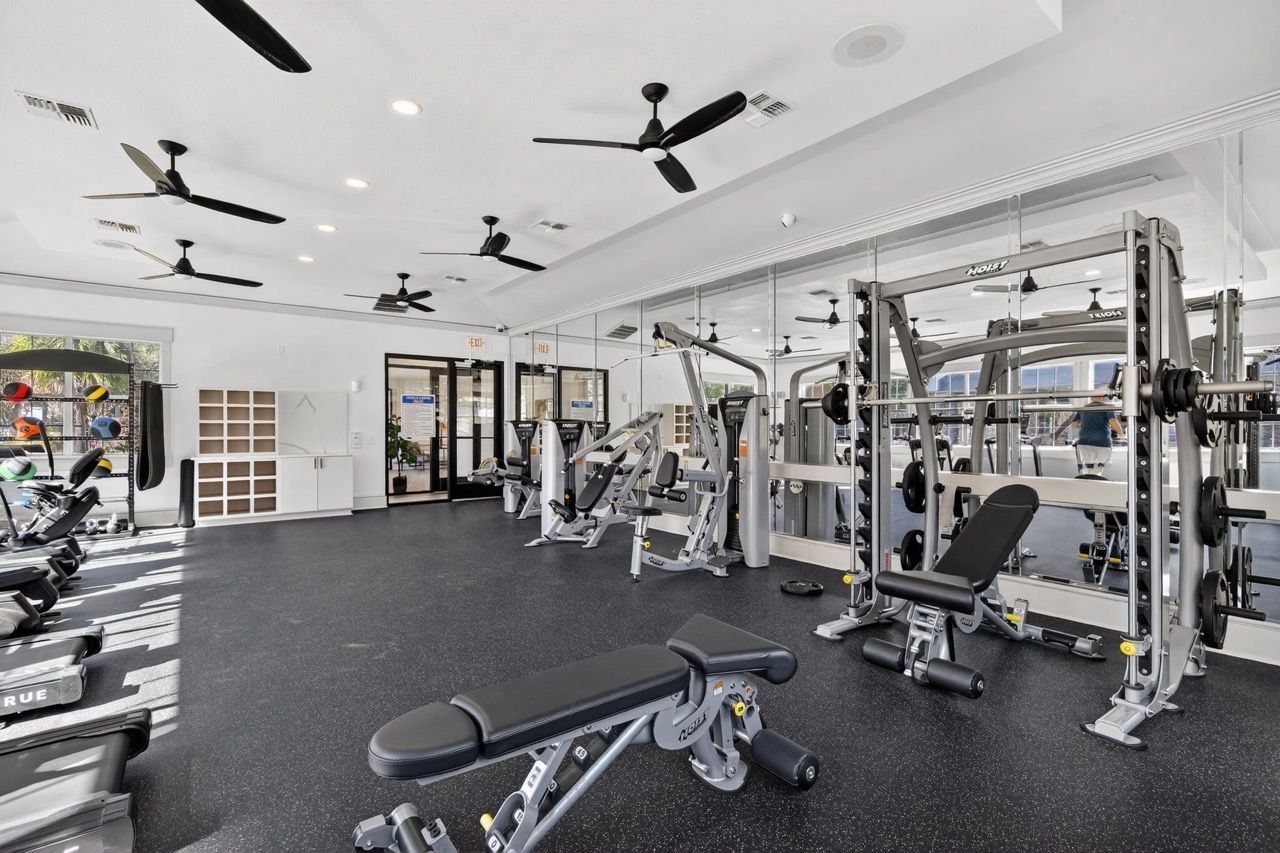 Modern fitness center in a residential community with treadmills, weight machines, and free weights.