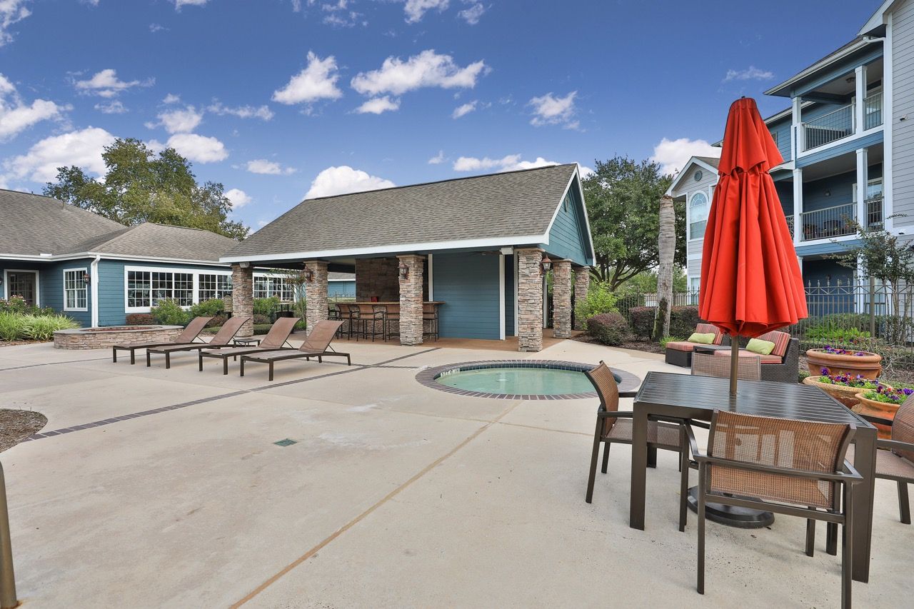 Outdoor pool courtyard with lounge chairs, a circular pool, and a stone pavilion.