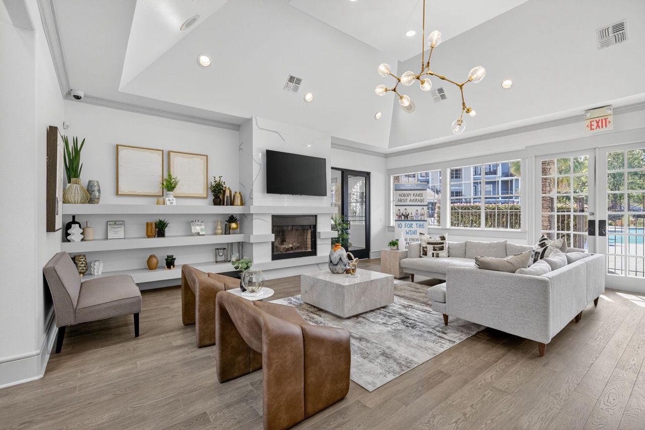 Bright modern apartment living room with a fireplace, TV, and gray sectional sofa.