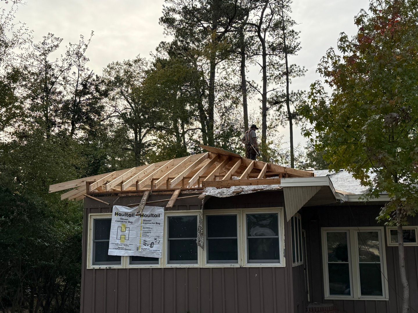 A man is working on a roof with a shovel.